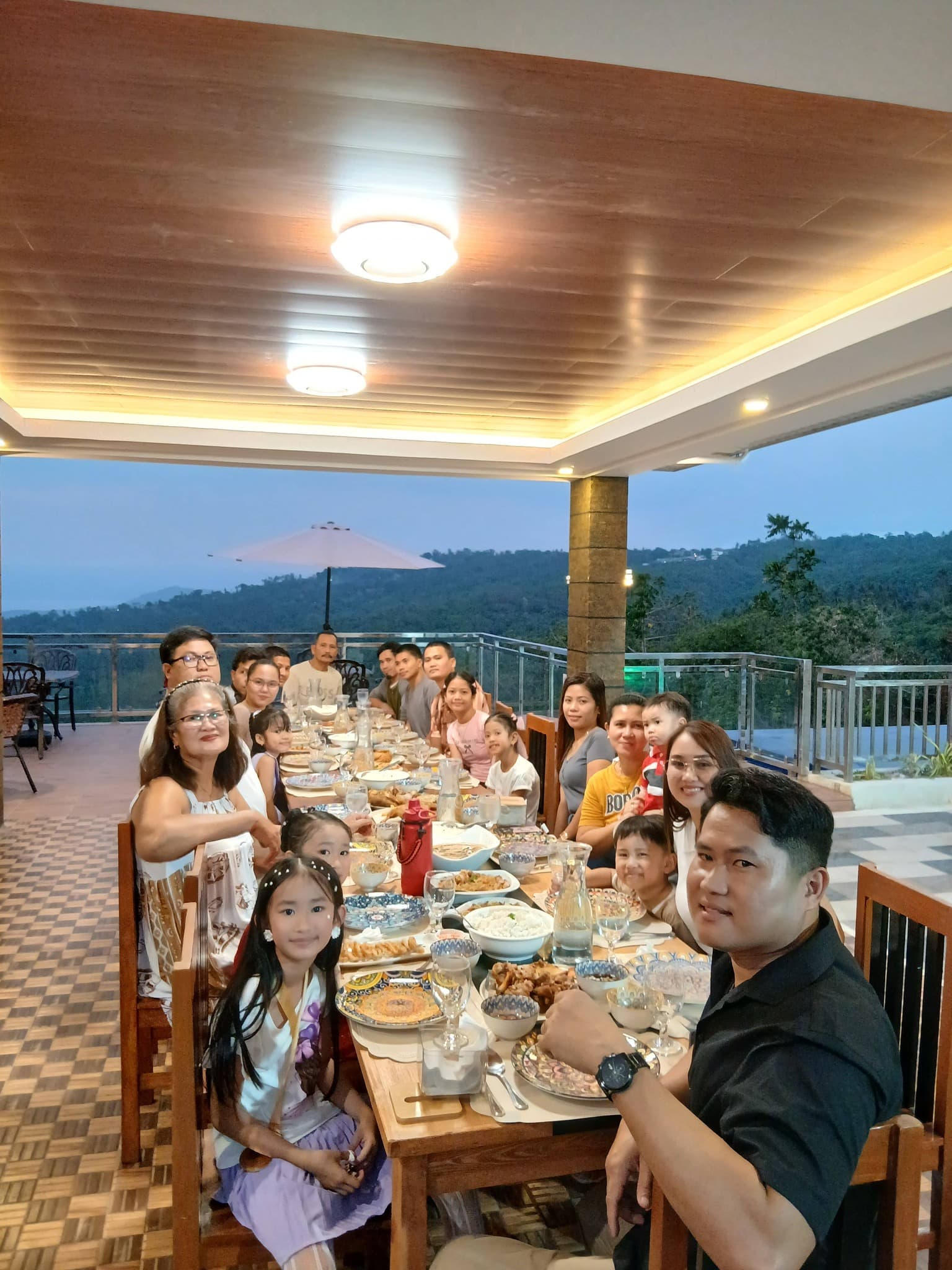 Family celebrating a special occasion at Merry Plates Restaurant terrace during golden hour — Highlights Taal Lakeview Resort Batangas